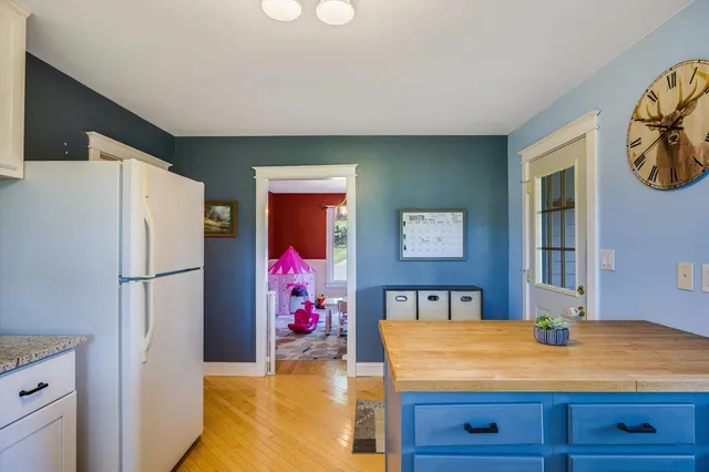 a view of a house with a big yard and large trees