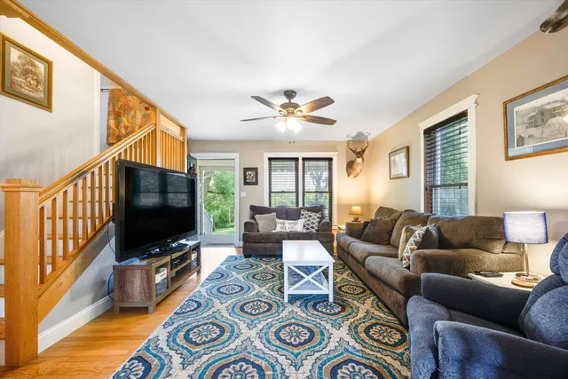 a living room with furniture a flat screen tv and a window