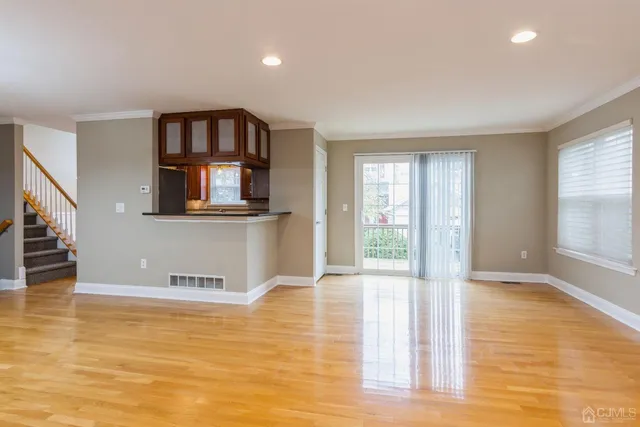 a view of a living room with wooden floor and a window