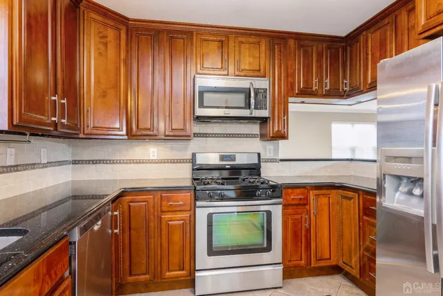 a kitchen with granite countertop wooden cabinets and a stove top oven