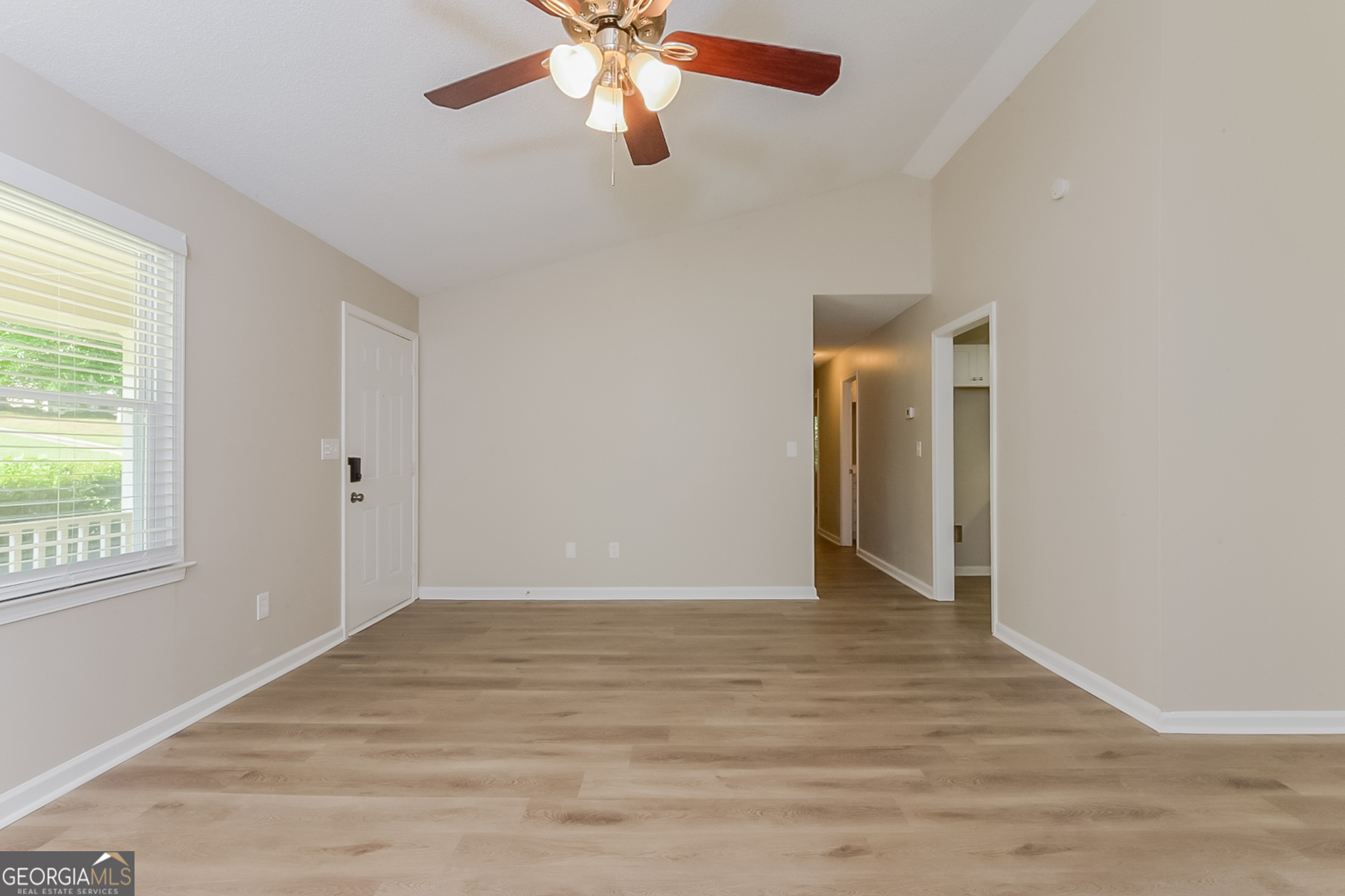 95 High Ridge Road Covington, GA 30014 - Photo 3 of 16 an empty room with wooden floor chandelier fan and windows