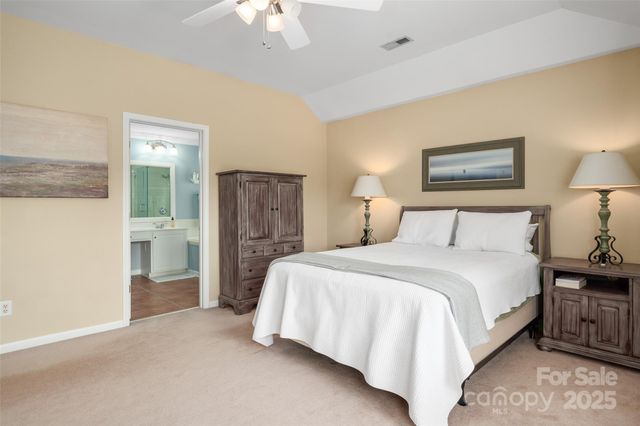 a spacious bedroom with a bed and a chandelier
