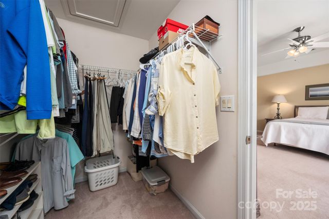 a view of walk in closet with clothes and shoes