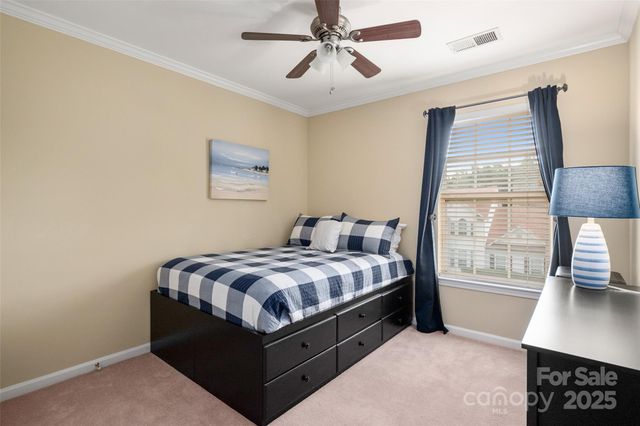 a bed sitting in a bedroom next to a window