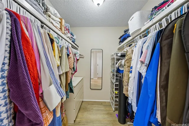 a view of walk in closet with clothes and shoes
