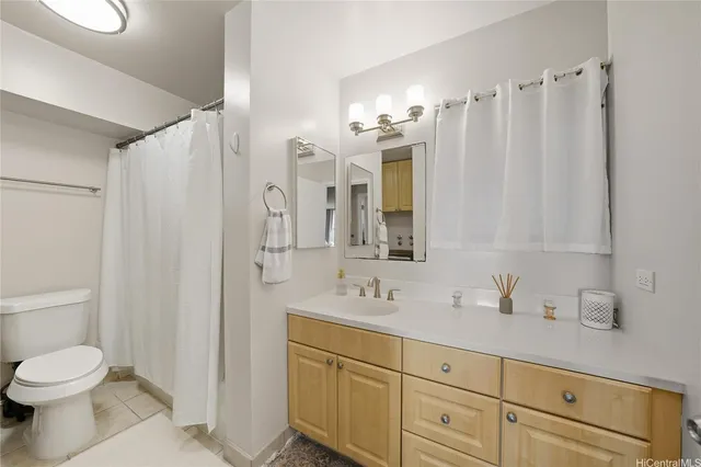 a bathroom with a granite countertop toilet and a sink