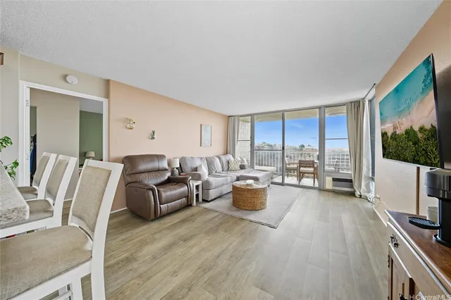 a living room with furniture a flat screen tv and a large window