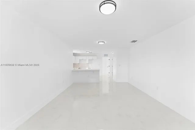 a large white kitchen with cabinets