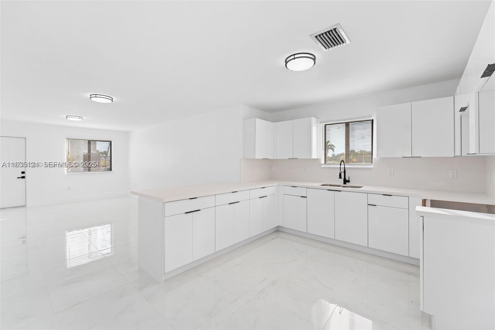 11997 Southwest 218th Street, Unit 1 Miami, FL 33170 - Photo 3 of 12 a large white kitchen with cabinets