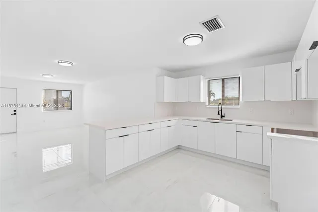 a view of a kitchen with white cabinets
