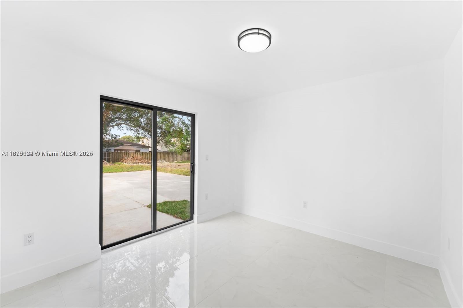 11997 Southwest 218th Street, Unit 1 Miami, FL 33170 - Photo 6 of 12 a view of an empty room with a window