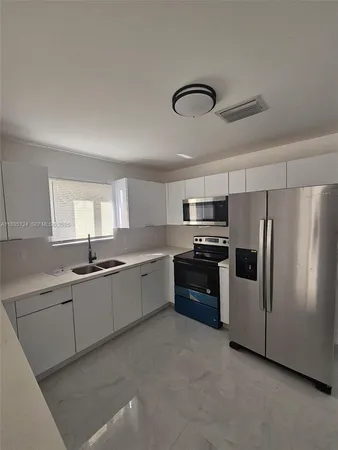 a large kitchen with cabinets and stainless steel appliances