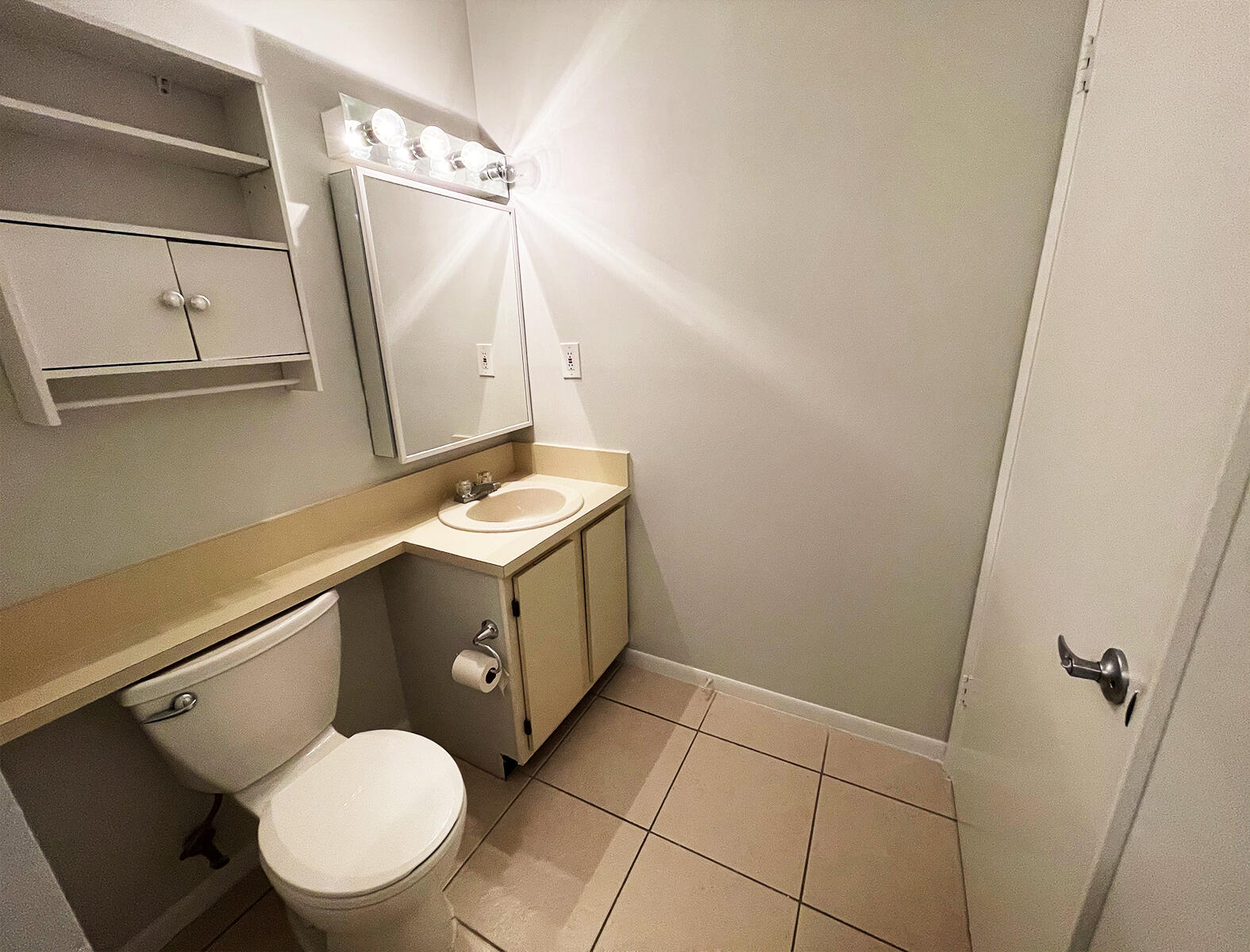 6572 Chasewood Drive, Unit E Jupiter, FL 33458 - Photo 17 of 23 a bathroom with a sink mirror vanity and toilet