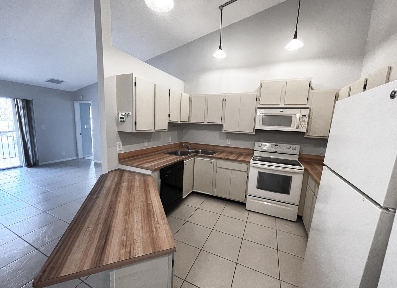 6572 Chasewood Drive, Unit E Jupiter, FL 33458 - Photo 2 of 23 a kitchen with stainless steel appliances a stove sink and microwave