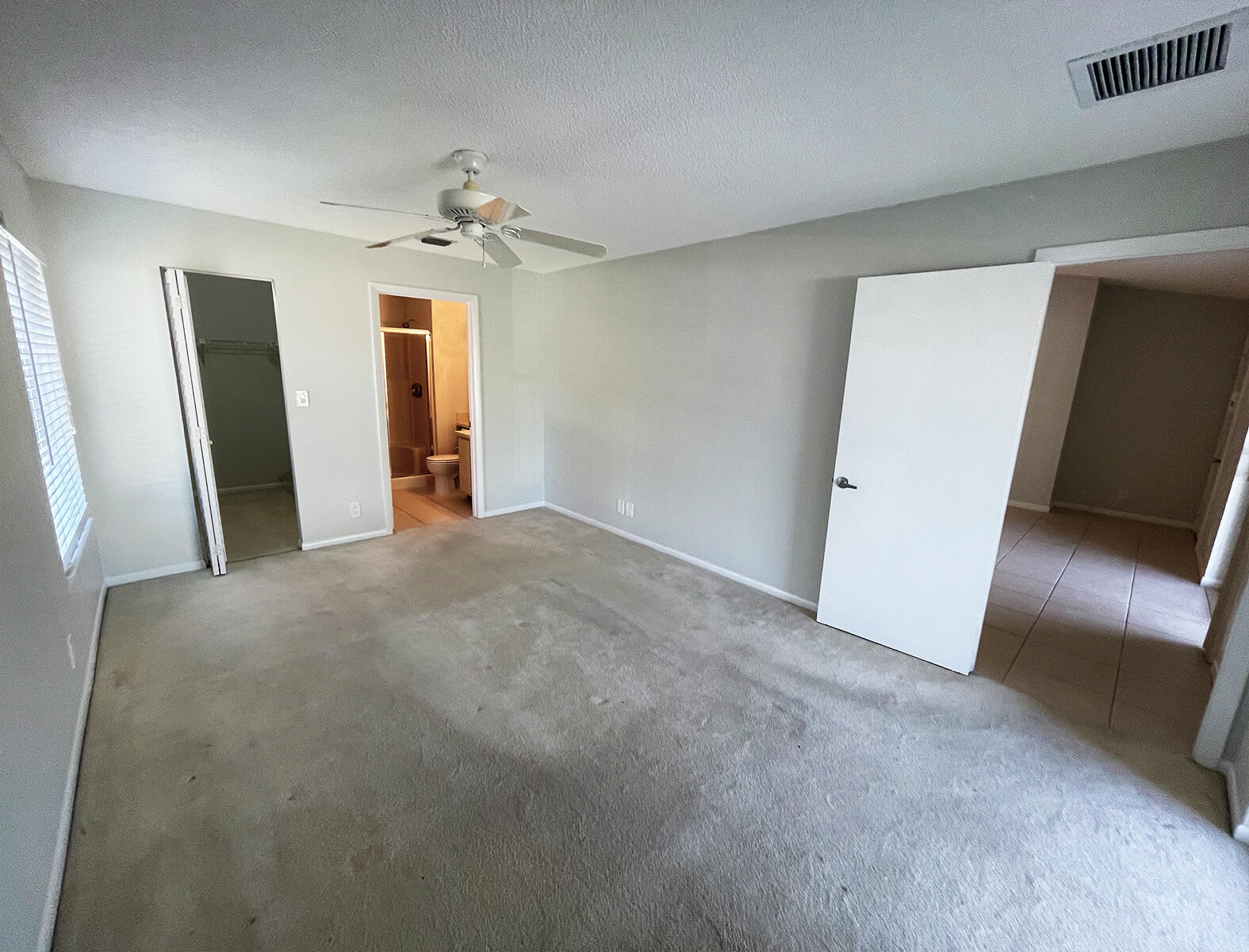 6572 Chasewood Drive, Unit E Jupiter, FL 33458 - Photo 5 of 23 an empty room with chandelier fan and refrigerator