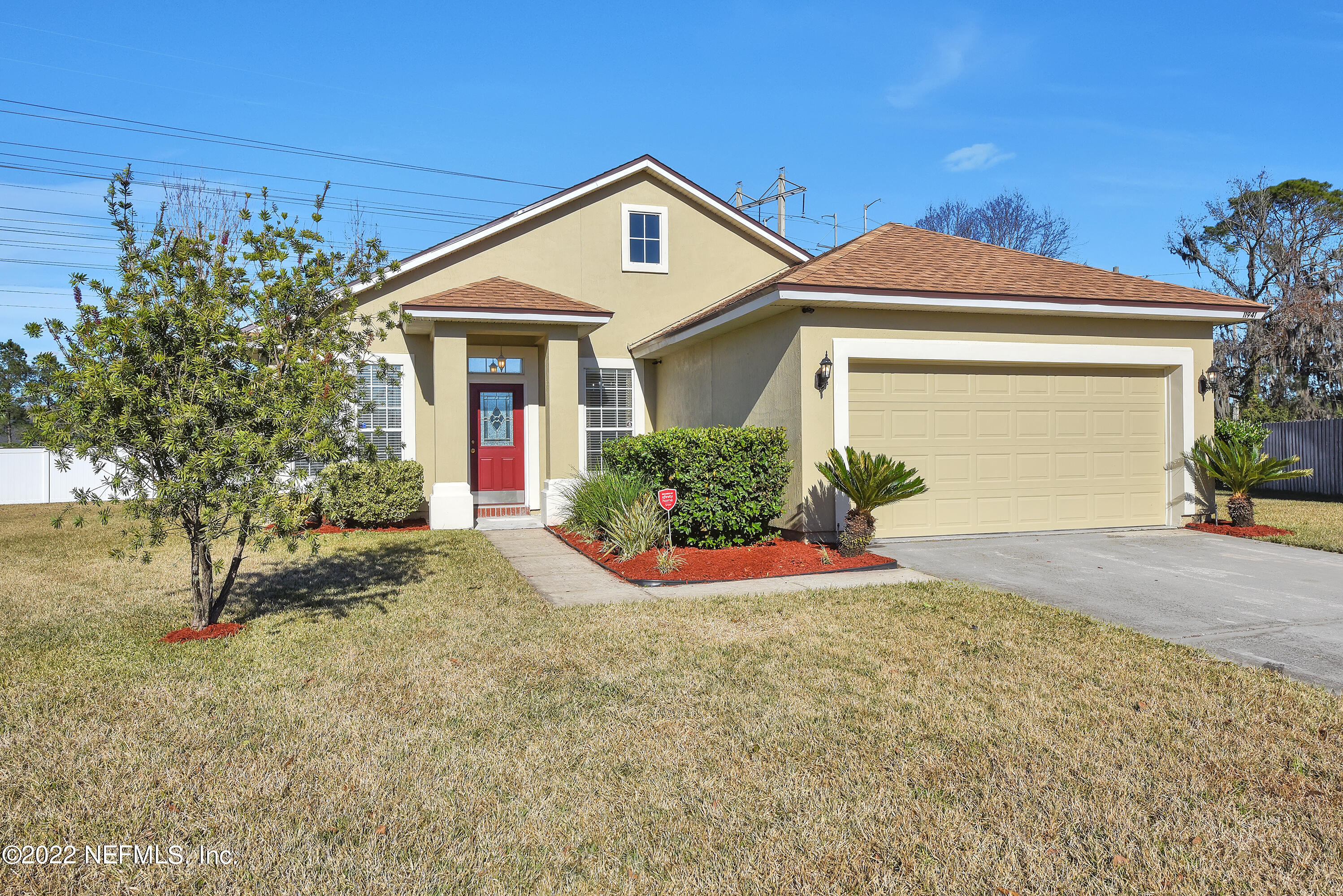 11941 Crooked River Road Jacksonville, FL 32219 - Photo 3 of 28 a front view of a house with a yard and garage