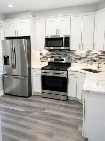 a kitchen with granite countertop a refrigerator stove and microwave