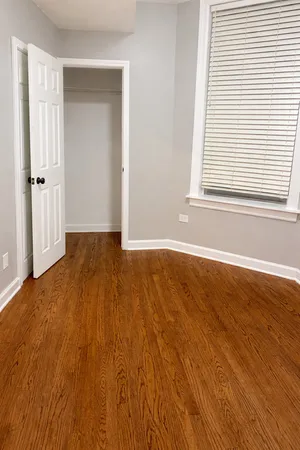 an empty room with wooden floor and a window