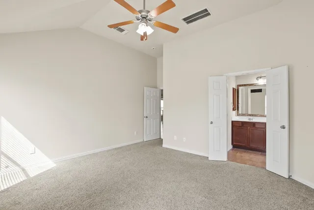 an empty room with closet and a chandelier fan