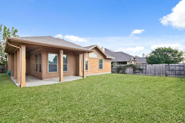 a view of a house with a yard and fence