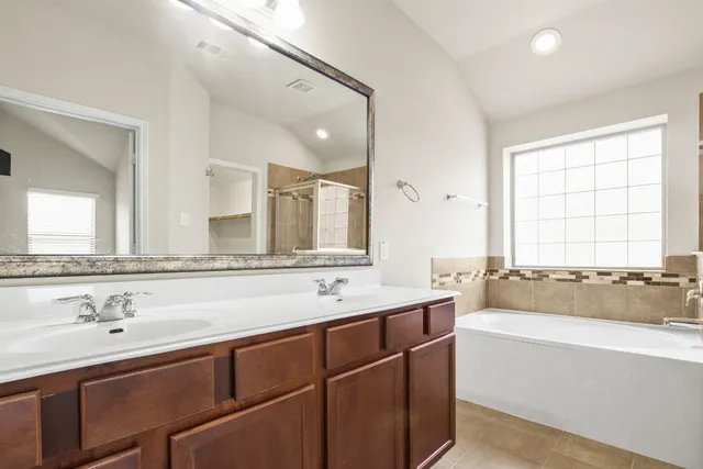 a bathroom with a tub sink and mirror