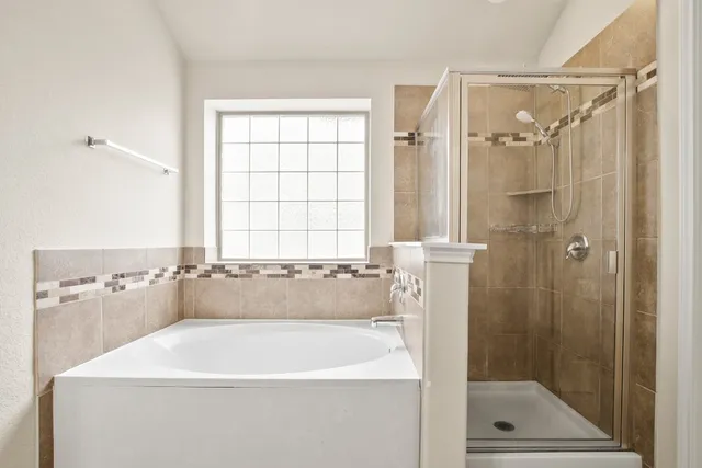 a bathroom with a tub shower and a sink