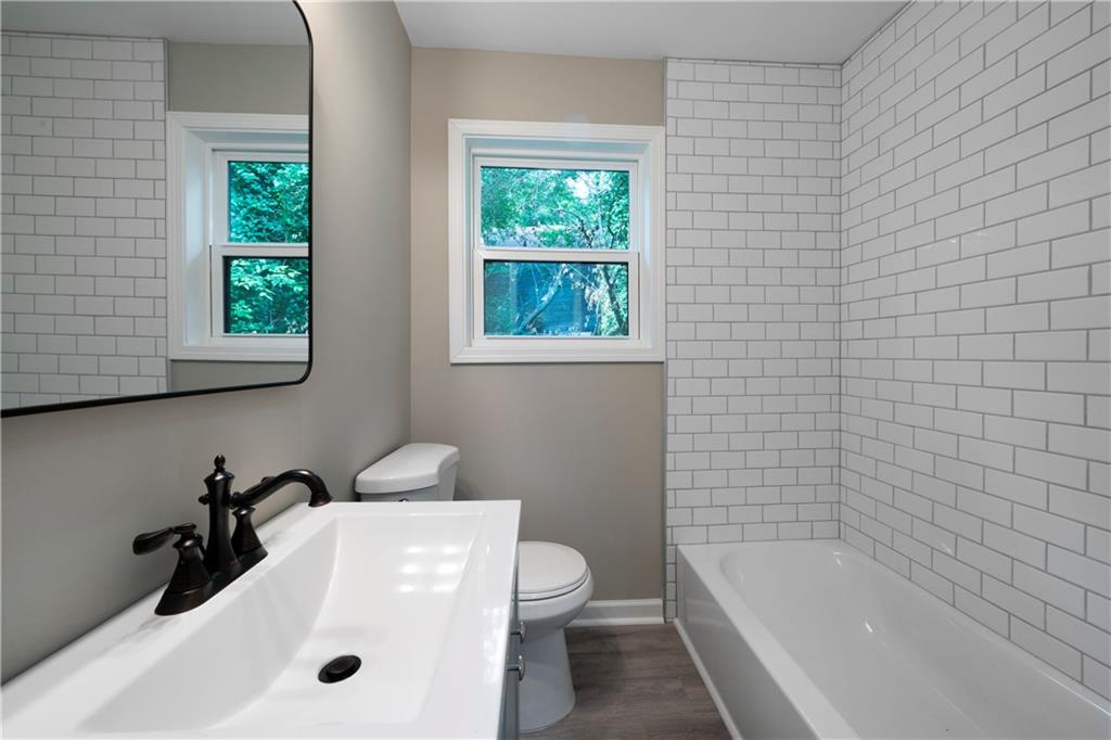 515 Harper Avenue Southwest Rome, GA 30161 - Photo 15 of 17 a bathroom with a tub a sink and a window
