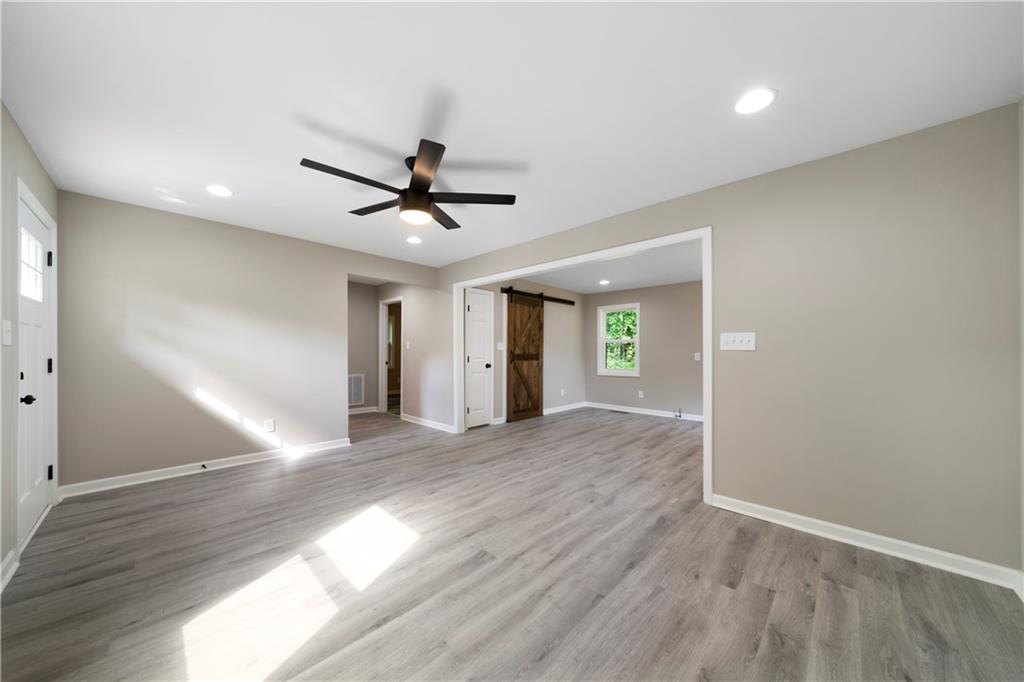 515 Harper Avenue Southwest Rome, GA 30161 - Photo 7 of 17 an empty room with wooden floor and a ceiling fan