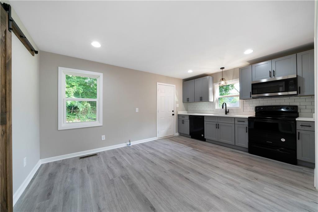 515 Harper Avenue Southwest Rome, GA 30161 - Photo 9 of 17 a kitchen with stainless steel appliances granite countertop a stove a sink and a microwave