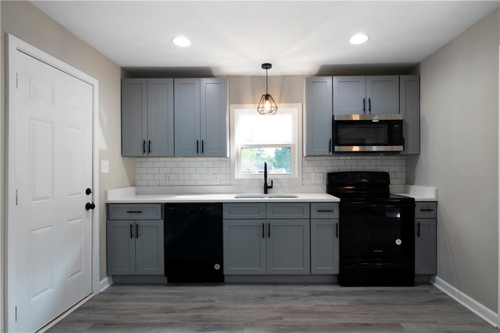 515 Harper Avenue Southwest Rome, GA 30161 - Photo 10 of 17 a kitchen with kitchen island granite countertop a sink cabinets and wooden floor