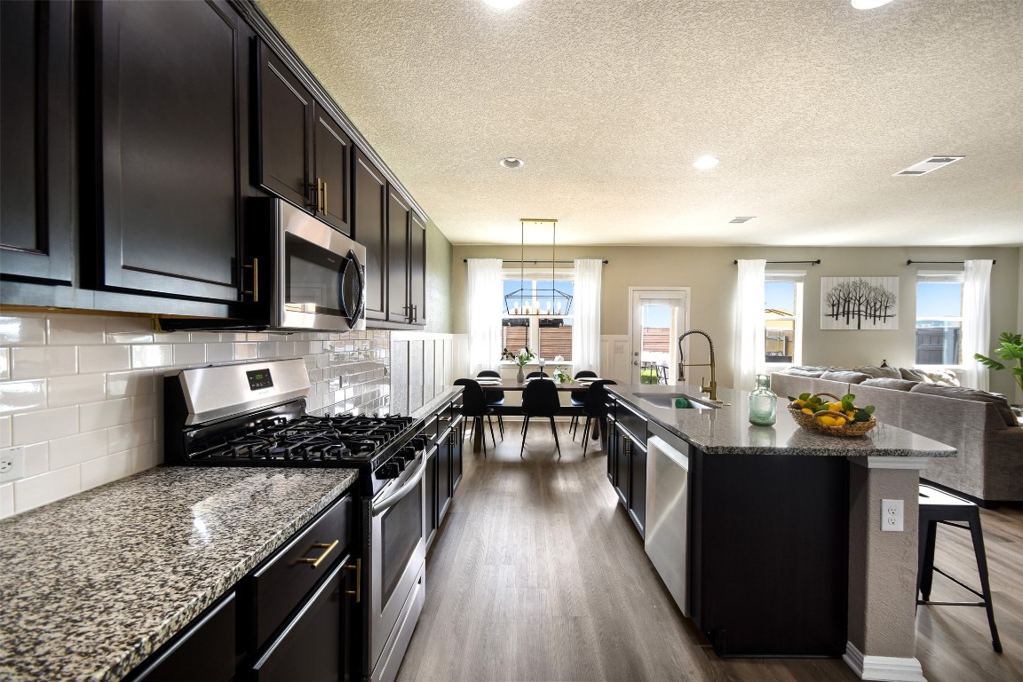 217 Frederick Drive Georgetown, TX 78626 - Photo 36 of 36 a kitchen with lots of counter top space a stove and wooden floor