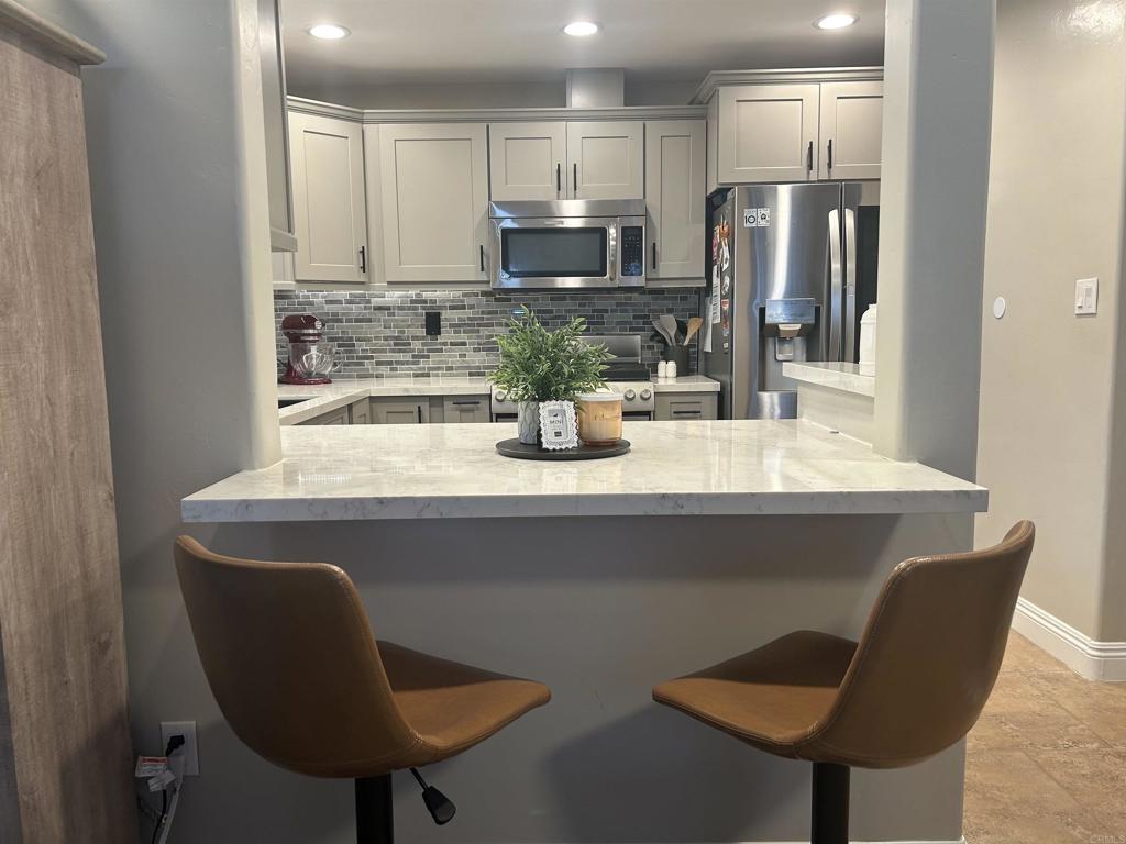 3546 Voyager Circle Carmel Valley, CA 92130 - Photo 5 of 28 a kitchen with a dining table chairs and refrigerator