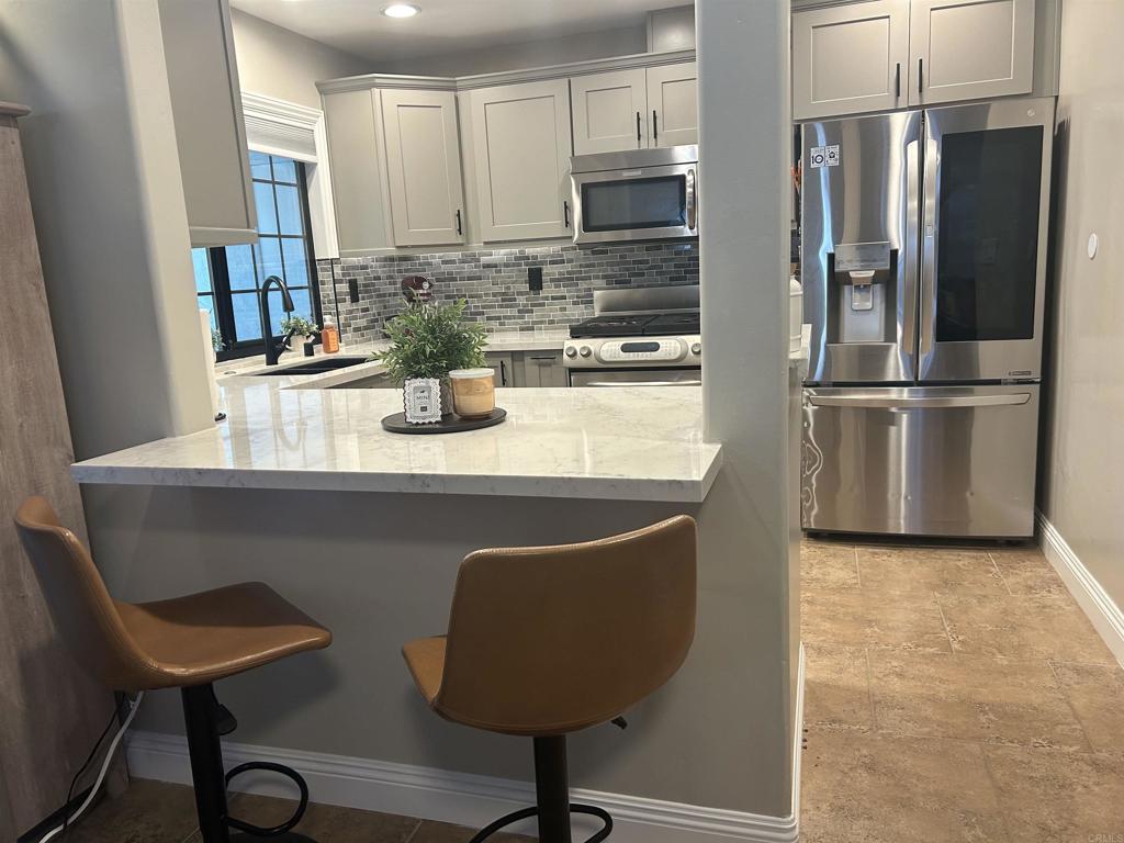3546 Voyager Circle Carmel Valley, CA 92130 - Photo 9 of 28 a kitchen with stainless steel appliances granite countertop a refrigerator a sink a stove and white cabinets