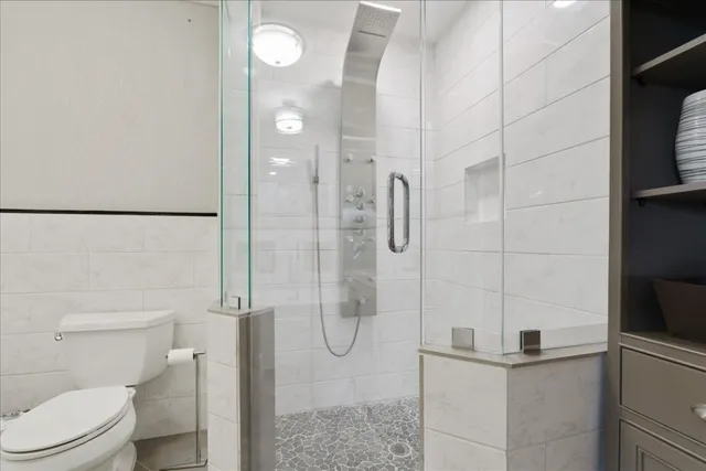 a bathroom with a granite countertop shower a toilet and sink