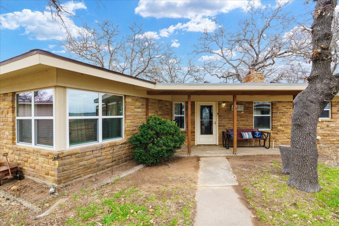 119 Lasso Loop Burnet, TX 78611 - Photo 2 of 35 a view of a house with a large window and flower plants