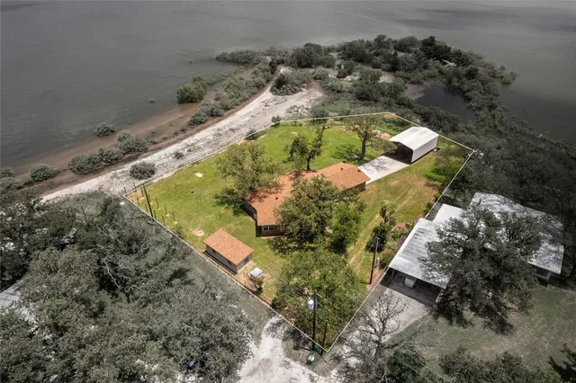 a aerial view of a house with a yard and lake view