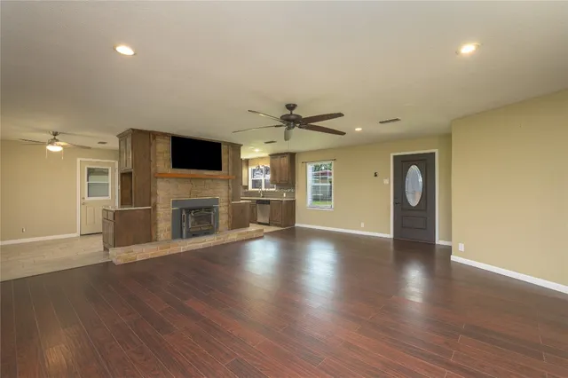 a view of a livingroom with a fireplace wooden floor and window