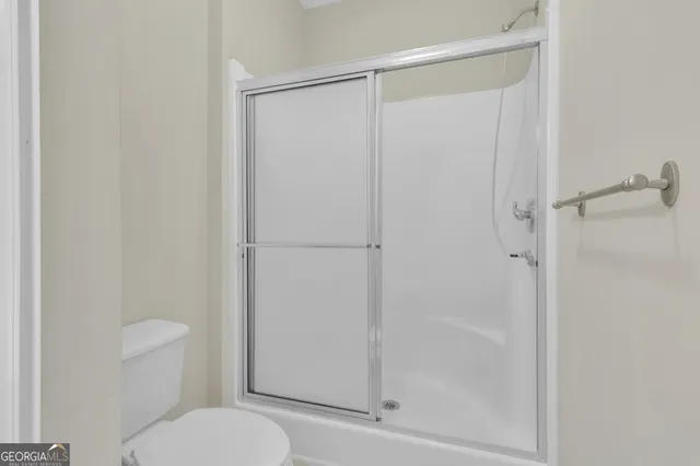 a bathroom with a shower a toilet and a sink