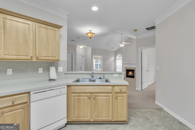 a kitchen with a sink dishwasher and cabinets with wooden floor