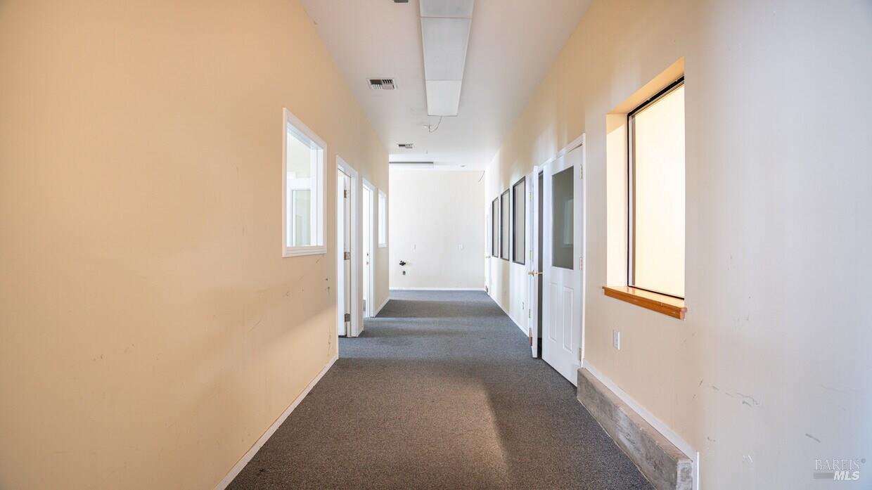 4770 Occidental Road Santa Rosa, CA 95401 - Photo 18 of 30 a view of a hallway with wooden floor and windows