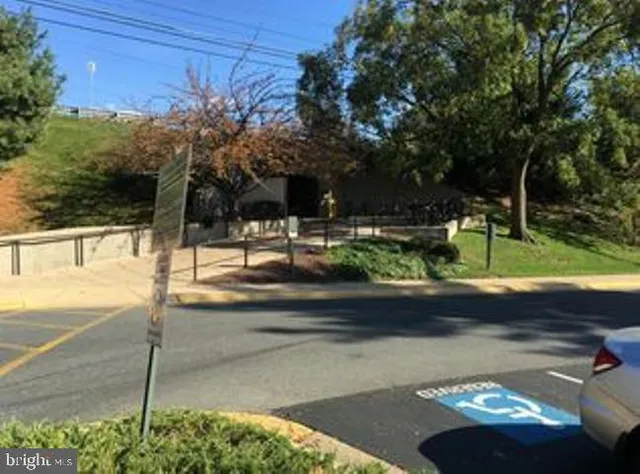 a view of a street with a bench and trees around