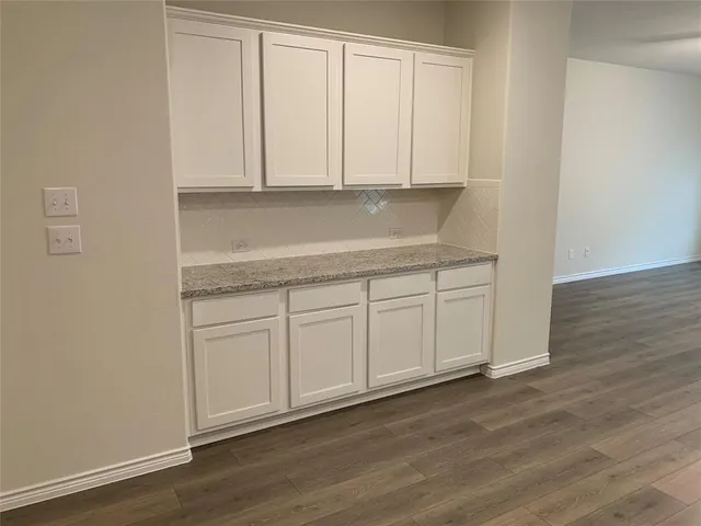 a view of a kitchen with white cabinets