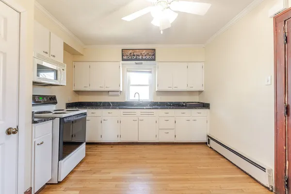 a kitchen with granite countertop white cabinets and white appliances
