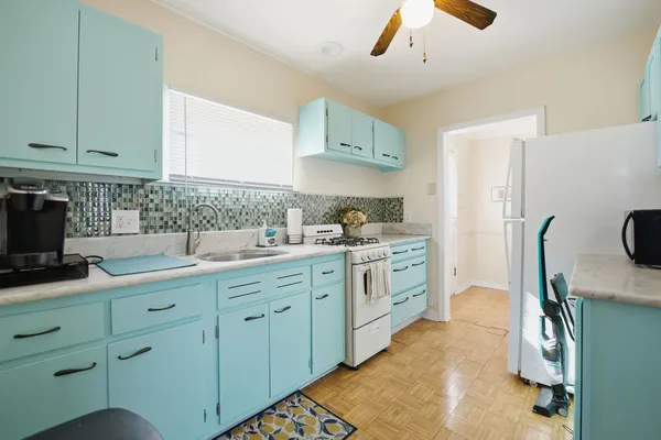 a kitchen with cabinets appliances and a sink