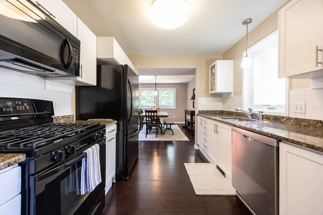 a kitchen with stainless steel appliances a stove sink microwave and cabinets