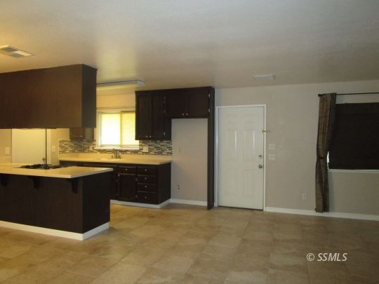 910 East Church Avenue Ridgecrest, CA 93555 - Photo 7 of 20 a kitchen with stainless steel appliances granite countertop a sink and cabinets