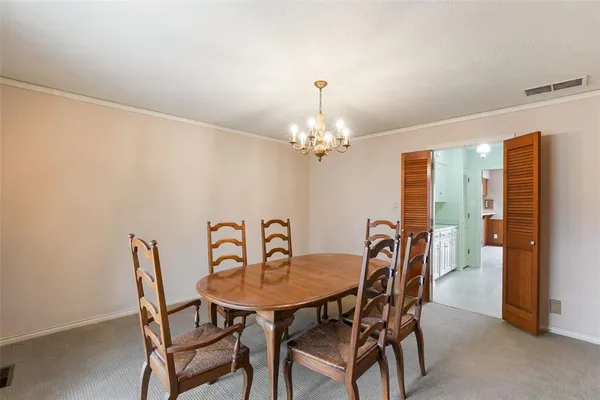a view of a dining room with furniture and chandelier