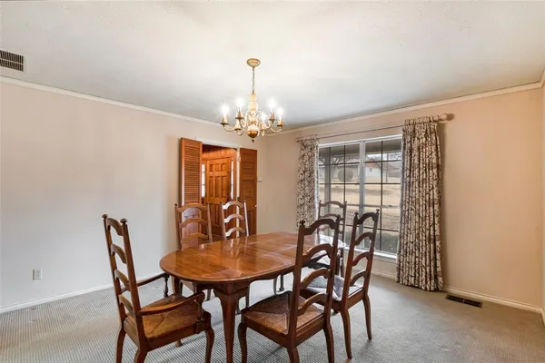 a view of a dining room with furniture and chandelier