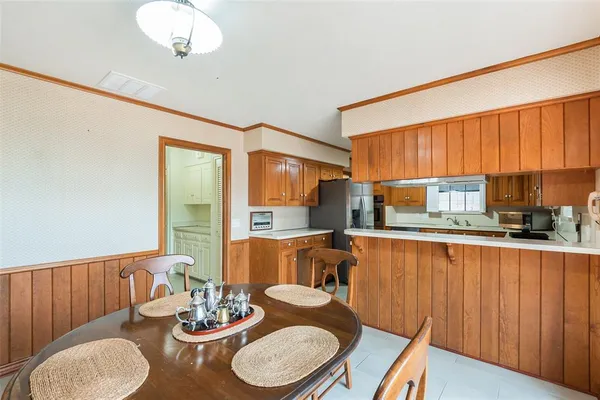 a kitchen with stainless steel appliances a table and chairs in it