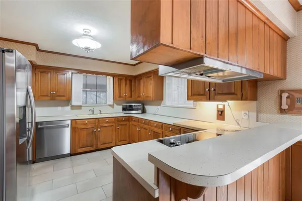 a kitchen with stainless steel appliances granite countertop a sink a stove and a refrigerator
